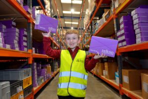 Jake Allen, inside the new distribution centre, holding boxes of ostomy products